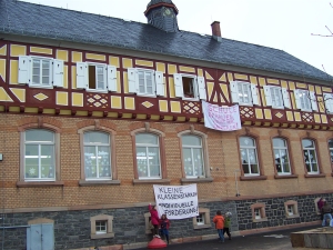 Schulgebäude mit Plakat